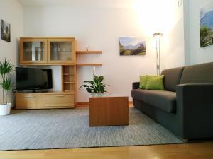 ein Wohnzimmer mit einem Sofa und einem TV in der Unterkunft Appartment Trojer in Meran