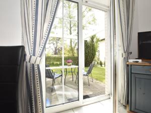 ツィングストにあるModern Apartment in Zingst Germany with Terraceのガラスのスライドドアからパティオ(テーブル付)へアクセスできます。