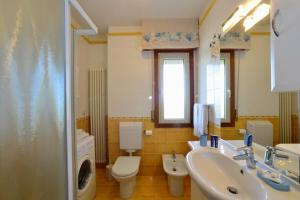 ein Badezimmer mit einem Waschbecken und einer Waschmaschine in der Unterkunft Condominio Al Cigno in Lignano Sabbiadoro