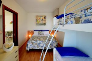 ein Schlafzimmer mit einem Bett und einem Etagenbett in der Unterkunft Condominio Al Cigno in Lignano Sabbiadoro