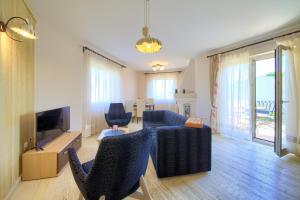 een woonkamer met een bank en een tv bij Summer House Magdalena in Malinska