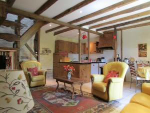 a kitchen and living room with yellow chairs and a table at lesChenes in Saint-Dolay