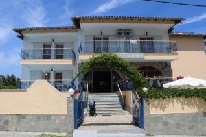 una casa blanca con un arco delante de ella en Vicky, en Chaniotis