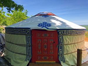 a yurt with a red door on a deck at Yourte Mongole in Mont-Roc