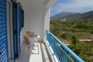 a balcony with a table and chairs on a house at Athena Kythera in Dhiakofti