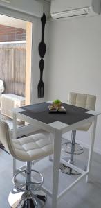 - une table et des chaises blanches dans la chambre dans l'établissement Lourdes Pyrénées, à Lourdes