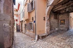 um beco numa cidade velha com edifícios em Santa Lucia Guest House em Rovinj
