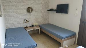 a small room with two beds and a table at Niki Apartments in Makry Gialos