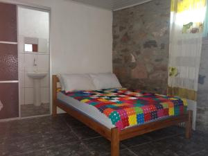 a small bed in a room with a bathroom at Pousada Orquídea in Igatu