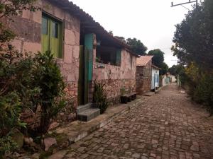 a cobblestone street in front of a pink building at Pousada Orquídea in Igatu