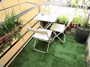 two chairs and a table on a balcony with plants at Casa della Musica in Parma