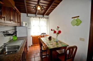una cocina con una mesa con un jarrón de flores. en Pancho Molina, en Puntallana