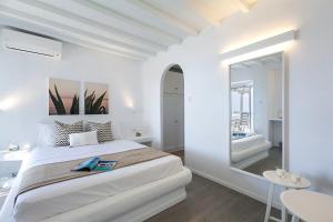 a white bedroom with a large bed and a mirror at Villa Gin & Tonic by Mykonos Mood in Agios Ioannis Mykonos