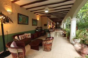 a living room filled with furniture and plants at Casa Quetzal Boutique Hotel in Valladolid