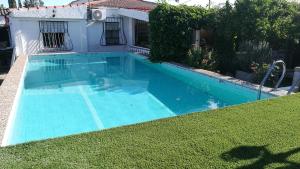a swimming pool in a yard next to a house at Casa de Campo Talavera in Talavera de la Reina