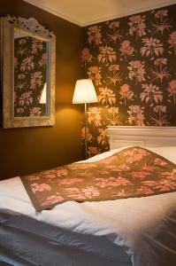a bedroom with a bed with a flowery wallpaper at sleeping in bruges in Bruges