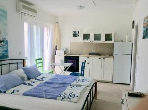 a bedroom with a bed and a small kitchen at Apartment Pin in Pinezici