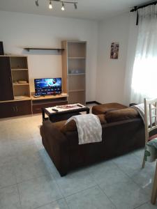 uma sala de estar com 2 sofás e uma televisão de ecrã plano em VUT "O Pazo" Sanxenxo os espera em Sanxenxo