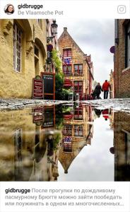een stadsstraat met een reflectie in het water bij sleeping in bruges in Brugge