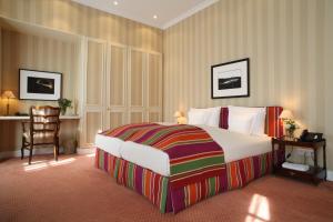 a hotel room with a large bed and a desk at Hotel Stadt Hamburg in Westerland
