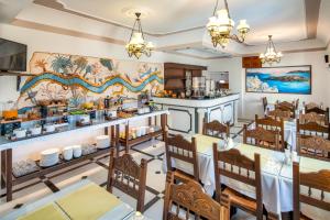 une salle à manger avec des tables et des chaises dans un restaurant dans l'établissement Astir Thira Hotel, à Fira