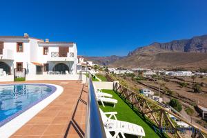 a villa with a swimming pool and mountains in the background at Villas Sicilia in Agaete