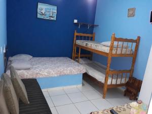 1 Schlafzimmer mit 2 Etagenbetten und einer blauen Wand in der Unterkunft Chalé do Tio Beto - Caraguatatuba in Caraguatatuba + 79 Fotos
