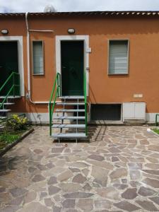 a house with a green door and stairs in front at Le Terrazze in Agropoli