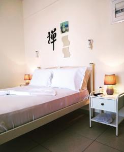a bed with white sheets and pillows in a room at Larissa in Skala