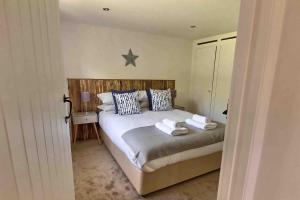 1 dormitorio con 1 cama con 2 toallas en Lovely Somerset Getaway en Taunton