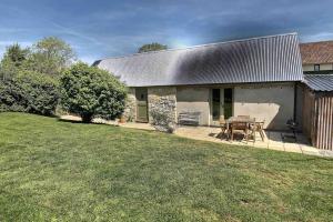 un granero con una mesa y sillas en un patio en Lovely Somerset Getaway, en Taunton