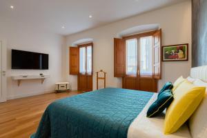 - une chambre avec un lit doté d'un couvre-lit bleu dans l'établissement Marcus Suite, à Cagliari