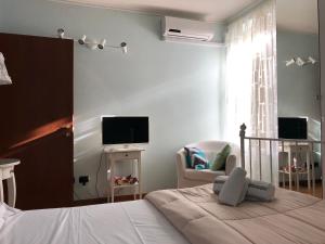 una camera con letto, sedia e televisore di AcquaTerraFuoco - City apartments a Como