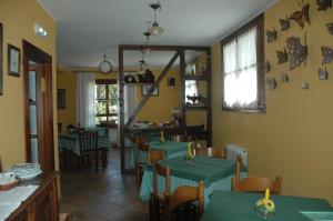 a restaurant with green tables and chairs in a room at Hotel Rural El Texu in Arriondas