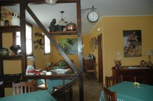 a dining room with a table and a clock on the wall at Hotel Rural El Texu in Arriondas