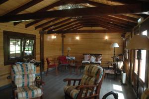 una sala de estar con sillas y una mesa en una cabaña en Hotel Rural El Texu, en Arriondas