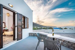 a view from the balcony of a house with a table and chairs at Agia Irini in Imerovigli