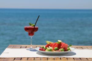 einen Obstteller und einen Drink auf dem Tisch in der Unterkunft Villa Augusto Boutique Hotel & SPA in Konaklı