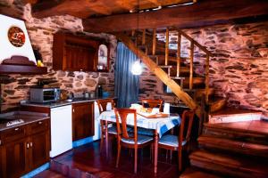 a kitchen with a table with chairs and a staircase at CASA RURAL BIERZO ENCANTADO in Valle de Finolledo