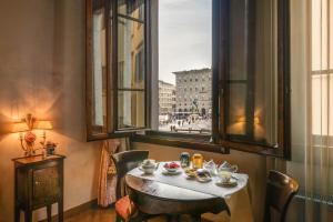 una mesa en una habitación con vistas a la ciudad en Residenza D'Epoca In Piazza della Signoria, en Florencia
