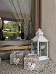 dos jarras con corazones y una casa de pájaros en una ventana en Hotel La Torre, en Castiglione dʼIntelvi