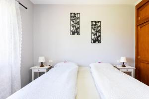 two beds in a white room with two lamps at Finca La Gaviota - Las Palmeras in Icod de los Vinos