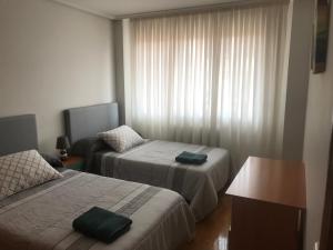 ein Hotelzimmer mit 2 Betten und einem Fenster in der Unterkunft Alfonso Peña in Santo Domingo de la Calzada