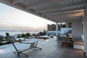 a patio with a hammock and a view of the ocean at Heaven's Hill in Naxos Chora