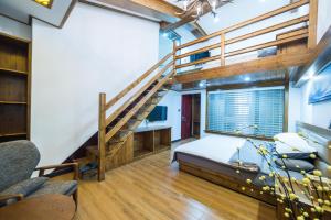 a loft bedroom with a bed and a staircase at W_Smart Motel Superior Hongcun in Yi