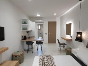 a living room and kitchen with chairs and a table at St.Thomas Beach Luxury Apartments in Pefki