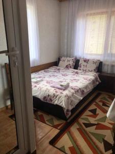 uma cama num pequeno quarto com uma janela em Guest house Denitsa em Trigrad