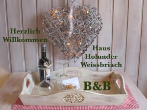 Una bandeja con dos botellas de vino y un corazón en B&B Haus Holunder Weissbriach, en Weissbriach