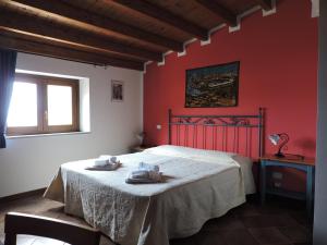 a bedroom with a bed with red walls and a window at Aziyz Camere in Castellammare del Golfo