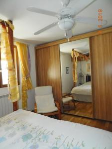 a bedroom with a bed and a ceiling fan and a mirror at Chez Nous. B & B in Bassy